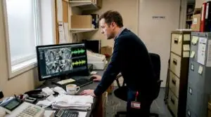 Manager reviewing CCTV audio system in small office